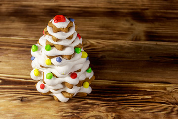 Gingerbread Christmas tree decorated with glaze on wooden table