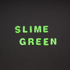 Slime green writing on black paper background