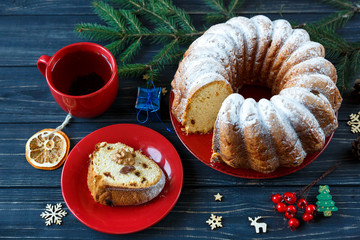 Traditional fruitcake for Christmas decorated with powdered sugar and nuts, raisins. Delicioius Homemade Pastry. New year and Christmas celebration concept