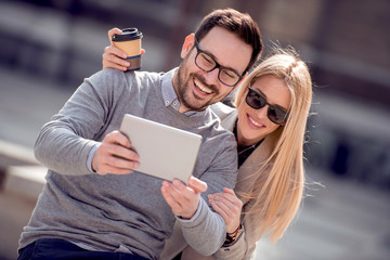 Cheerful couple using digital tablet