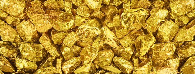 |Big panorama photo of many golden nuggets close-up. Wide background of shiny golden bars. Golden...