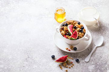 Obraz na płótnie Canvas Muesli with Nuts Yogurt and fresh Figs Blueberry on the gray Background.Granola Healthy Breakfast. Sweet food Dessert. Snack Dry Diet Nutrition Concept.Top View. Flat Lay.Copy space for Text