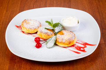 Delicious syrniki with cream