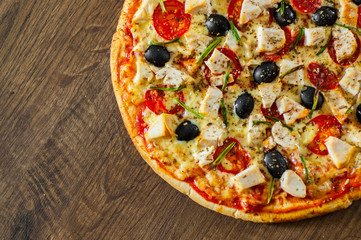 Pizza with Chicken meat, Mozzarella cheese, tomato, olive. Italian pizza on wooden background