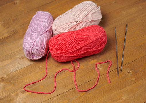 balls of woolen yarn for knitting on wooden background