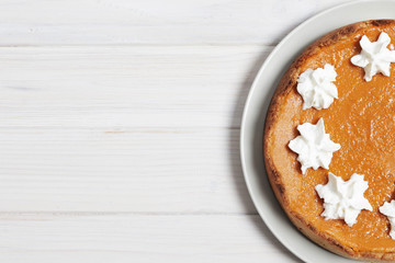 Closeup of pumpkin pie with whipped cream. Nuts and pumpkin. Pumpkin pie on a white wooden table. Place for text. Flat lay