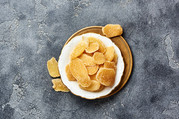 Dried sweet ginger with sugar on a gray table. Top view.