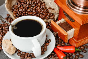Cup of coffee with steam, coffee beans, chocolate pieces, cinnamon sticks, white and brown sugar,...