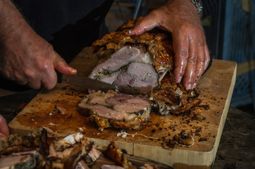 The hands of the chef knife pork porchetta cut
