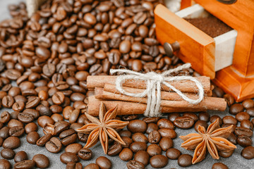 Cup of coffee with steam, coffee beans, chocolate pieces, cinnamon sticks, white and brown sugar, and scoop on burlap background.