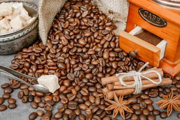 Cup of coffee with steam, coffee beans, chocolate pieces, cinnamon sticks, white and brown sugar,...