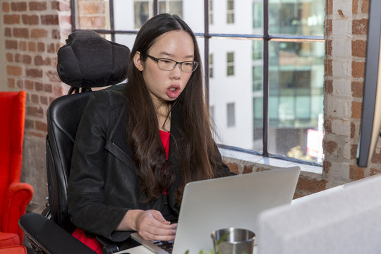 Woman with muscular dystrophy working in office