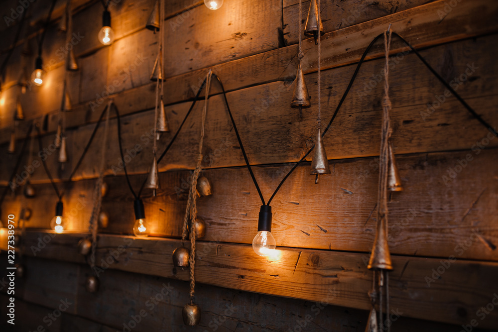 Wall mural Garland lamps over wooden board fence. Decoration background.Vintage light bulb on wooden wall