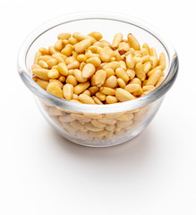 Peeled pine nuts. In glass bowl. Aerial view (from above, top view). Isolated on white background.