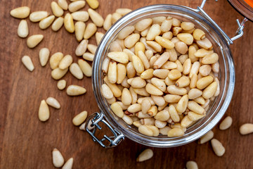 Peeled pine nuts. Aerial view (from above, top view). Foreground (Close-up). Wood background Rustic, natural and homemade appearance.
