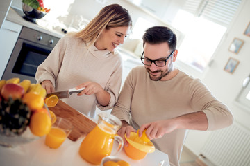 Couple with orange juice in the kitchen