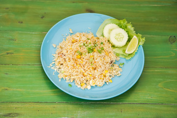 Fried rice with crab meat in dishes put on the green table.