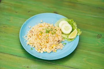 Fried rice with crab meat in dishes put on the green table.
