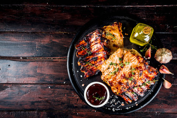 Grilled meat concept. bbq pork ribs with barbeque sauce, olive oil. fresh herbs copy space