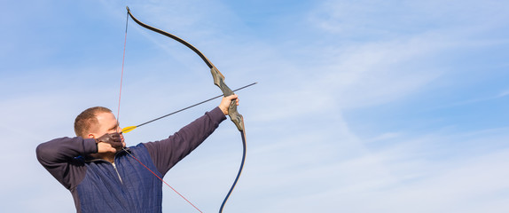 Athlete aiming at a target and shoots an arrow. Archery. Banner
