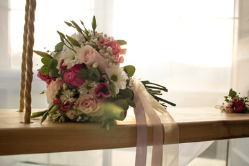 Wedding bouquet close-up on indoor swing on romantic wedding background soft focus
