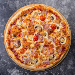 Pizza with mushrooms and ham on grey background