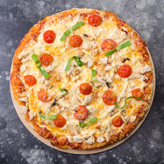 Pizza with chicken and tomatoes cherry on dark grey background top view. Italian cuisine. square photo