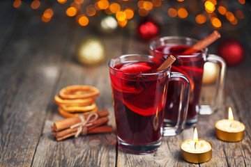 Mulled wine in glasses with spices on wooden table