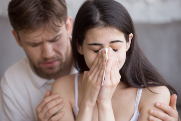 Close up girl hold handkerchief crying guy calms comforts her, apologizing after quarrel,...