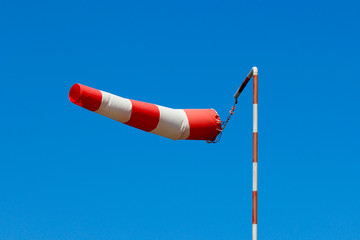 A fully extended with strong wind windsock against the blue sky