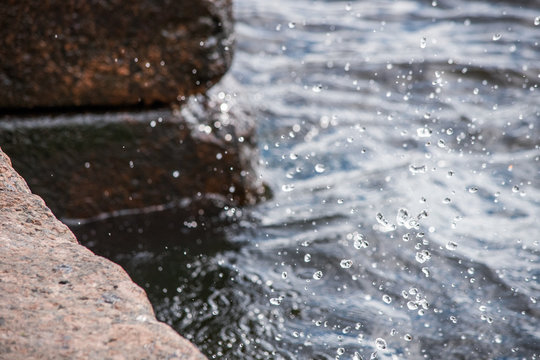 Flying water drops on a stone pier © savelov