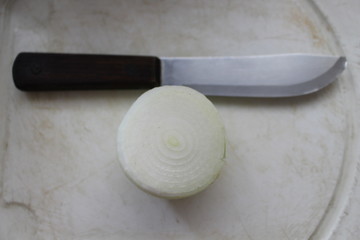 Onion and knife on a table.
