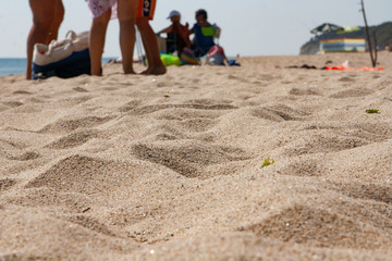 Fototapeta na wymiar Beach sand near and people on the background