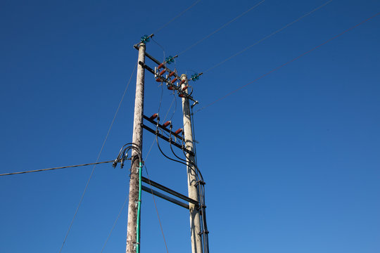 Wooden electric pole on blue sky background