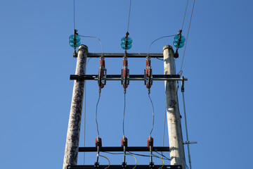 Wooden electric pole on blue sky background