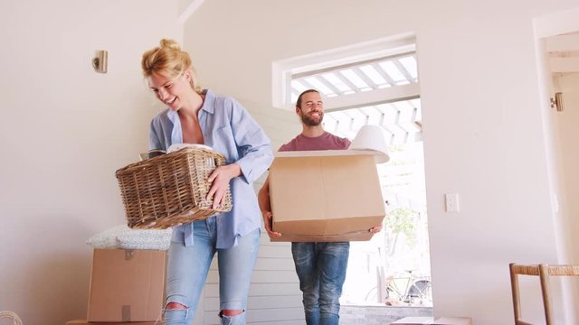 Slow Motion Shot Of Couple Carrying Boxes Into New Home On Moving Day