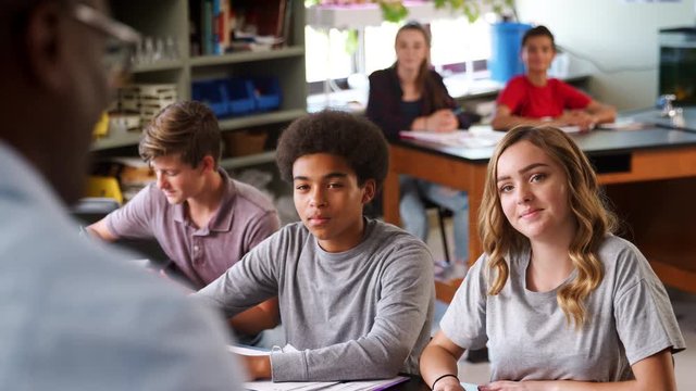 Male High School Tutor Teaching Students In Biology Class