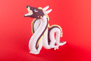 Clay dragon figure staying on red background