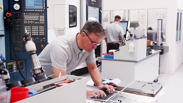 Mature Male Engineer Using CAD Programming Software On Laptop