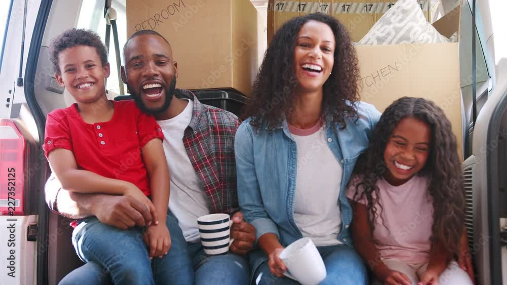 Sticker portrait of family sitting in back of removal truck on moving day shot in slow motion