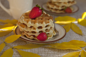 Waffles for breakfast, decorated with autumn leaves, berries