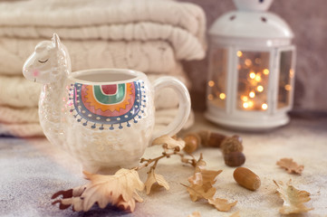 Cup of tea in trendy llama shape mug autumn leaves © allasimacheva