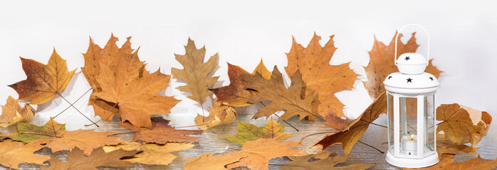White and red candle lantern with autumn leaves