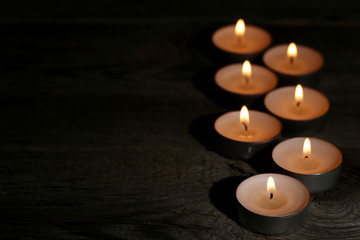Fototapeta na wymiar White burning candles on black background