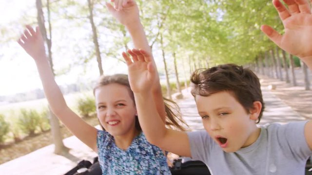 Two Kids Have Fun Standing Up And Waving Through Car Sunroof