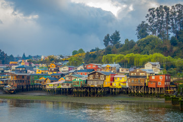 Outdoor view of colorful houses on stilts palafitos in the horizont located in Castro, Chiloe Island