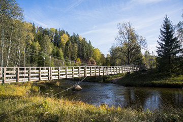 Fototapeta na wymiar Suspension bridge on a rope on the background of the autumn landscape.
