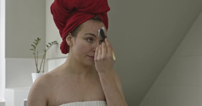 Applying face mask in bathroom