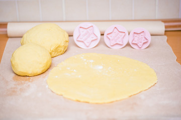 Christmas baking. Making gingerbread biscuits. Cookie dough in heart and star shape on kitchen...
