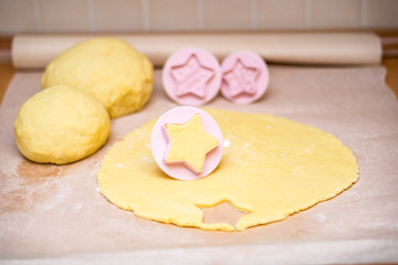 Christmas baking. Making gingerbread biscuits. Cookie star shape on kitchen counter.